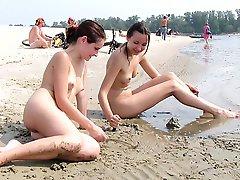 Nudist girls have fun with each other at the beach