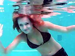 Slim redhead in bikini gets naked underwater