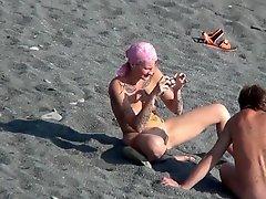 MILF nudist is getting naked on the beach