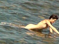 Tall brunette poses naked in the sea